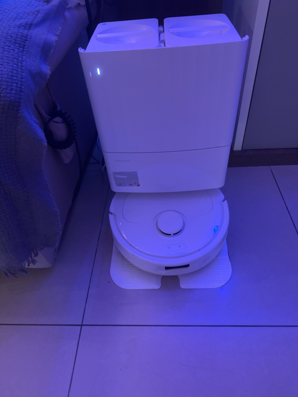 Robô aspirador Roborock junto à base, instalado na sala.