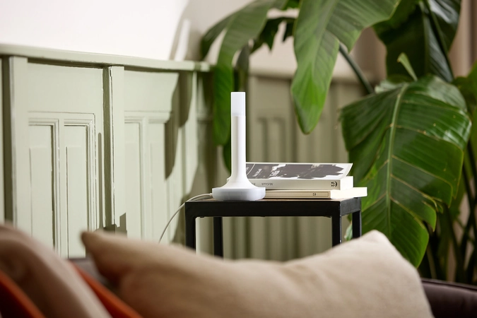 Home Assistant Connect ZBT-2, com base e antena vertical, sobre uma mesa.